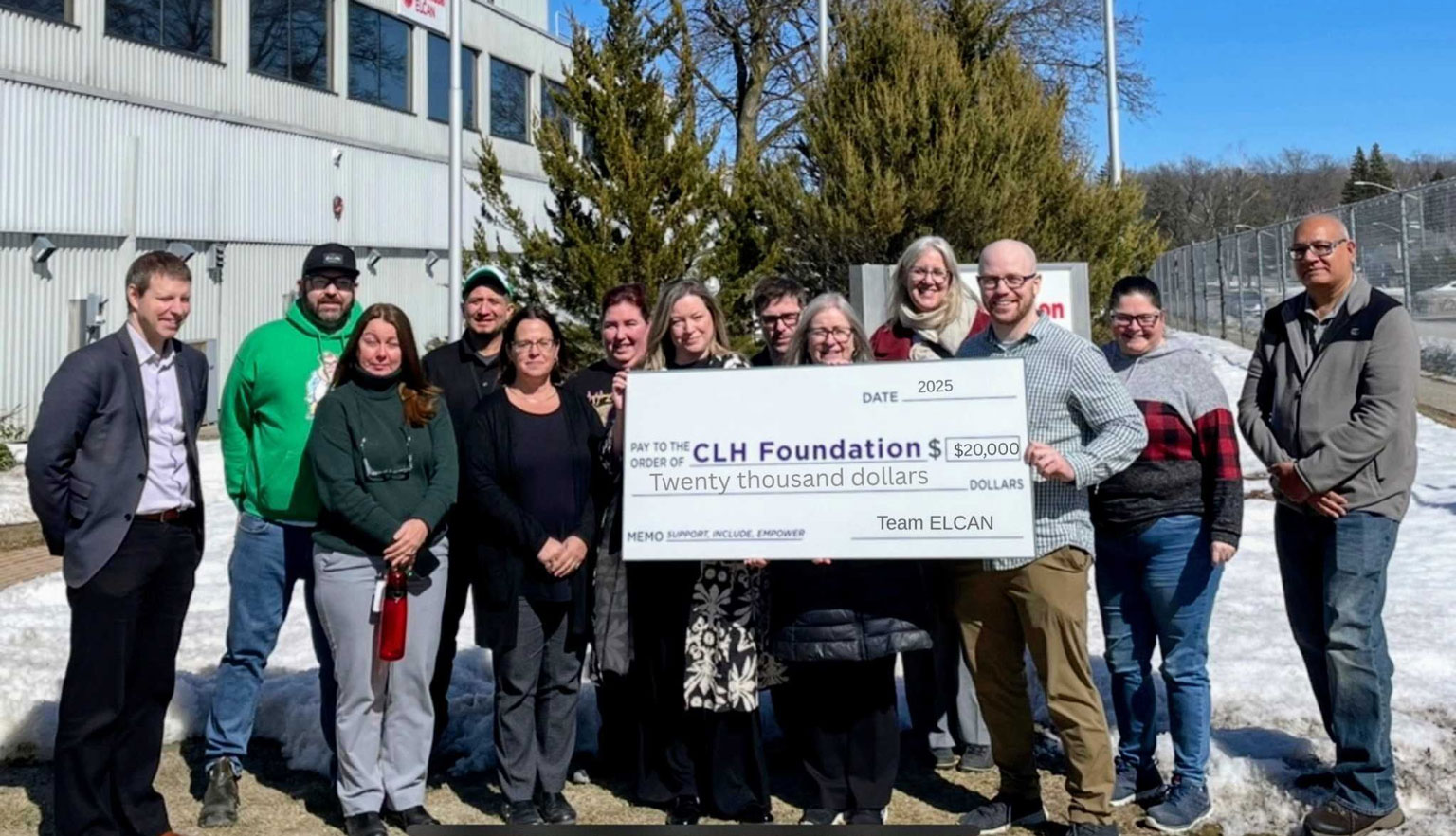 13 Elcan employees hold up a giant cheque for the CLH Foundation for $20,000